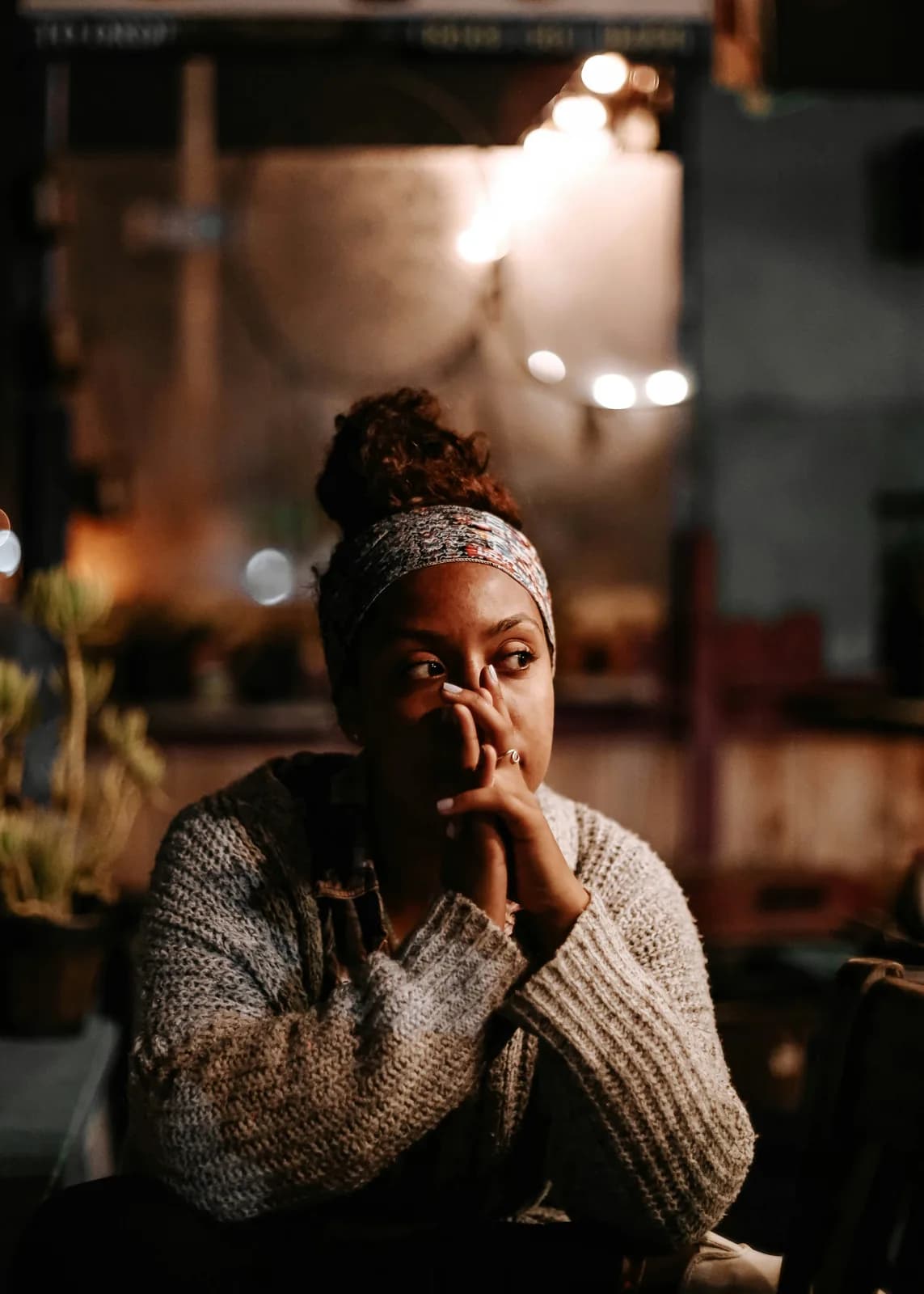 A woman sitting at a table, thinking